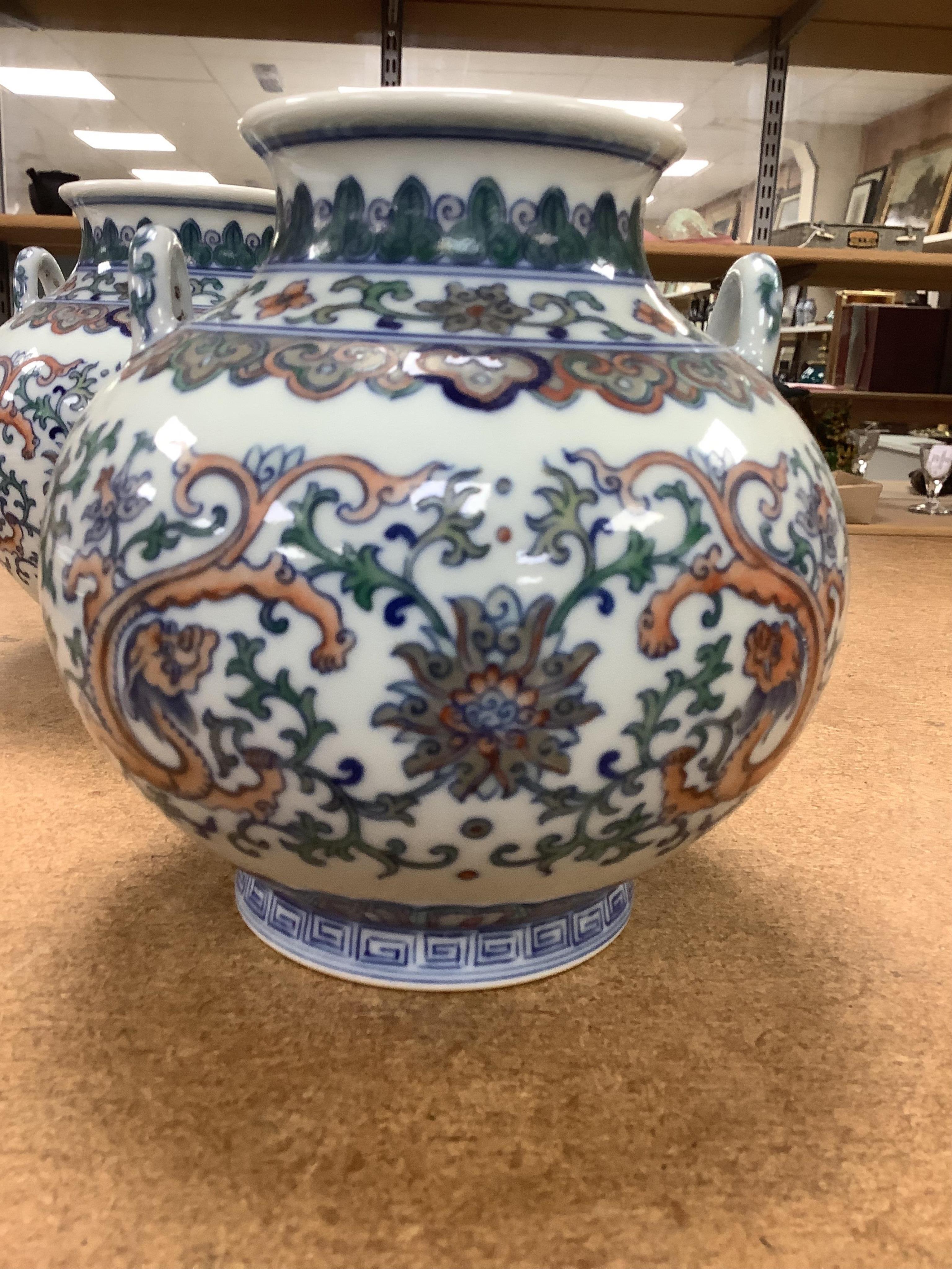 A pair of Chinese porcelain doucai twin handled ‘dragon’ jars, 14cm high. Condition - good